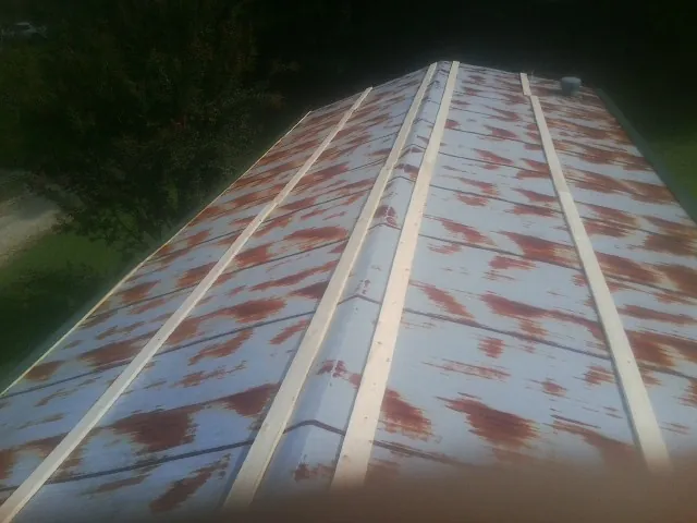 Rusted metal roof panels with new wood purlins before replacement — Storm Damage Roof Repair in Milanville by Roofing Brothers